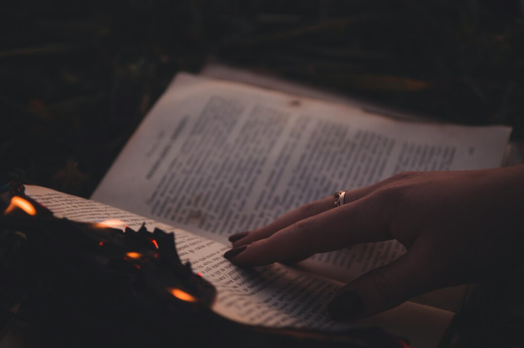person turning book page at night